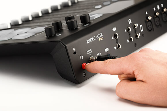 Finger pressing RØDECaster Pro power button