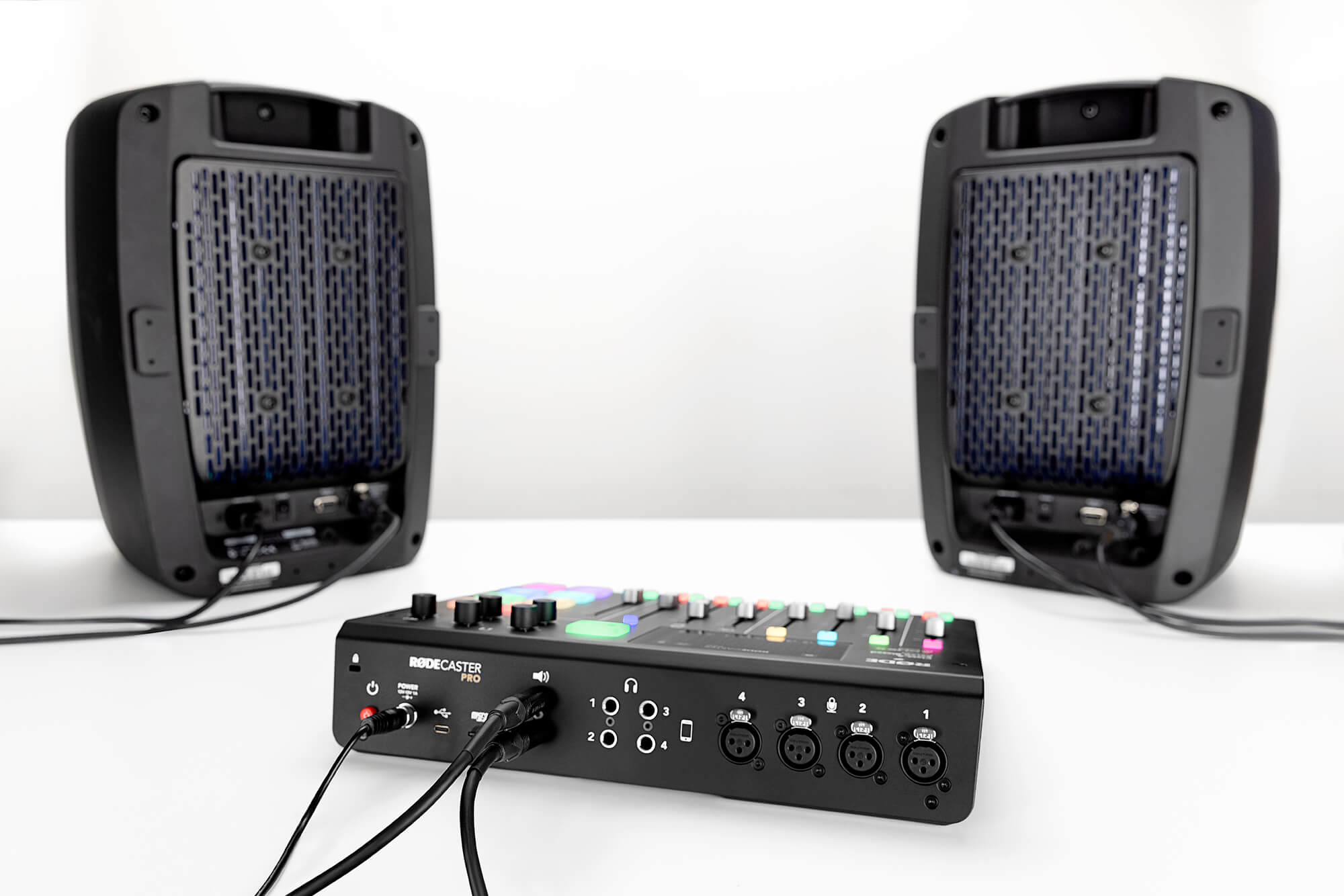 Pair of Event Opal speakers connected with TRS to XLR cables to the back of the RØDECaster Pro