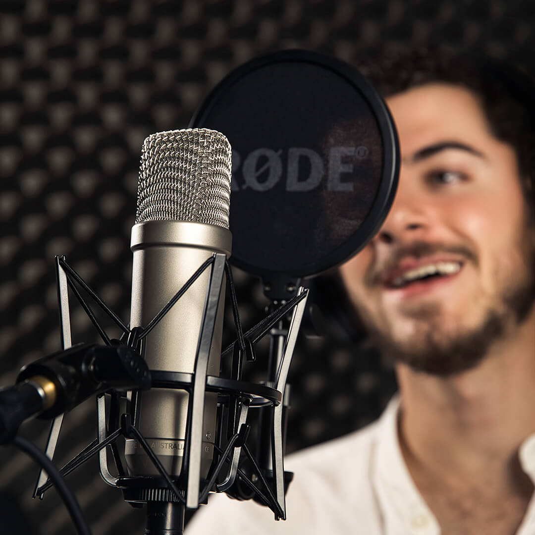 man singing into microphone with popfilter