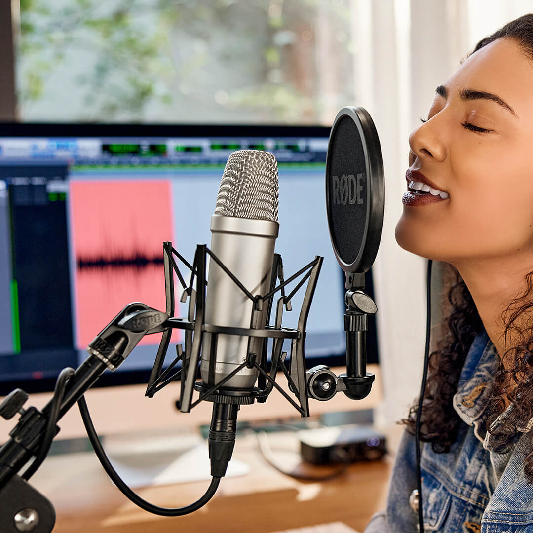 girl playing a guitar singing into microphone