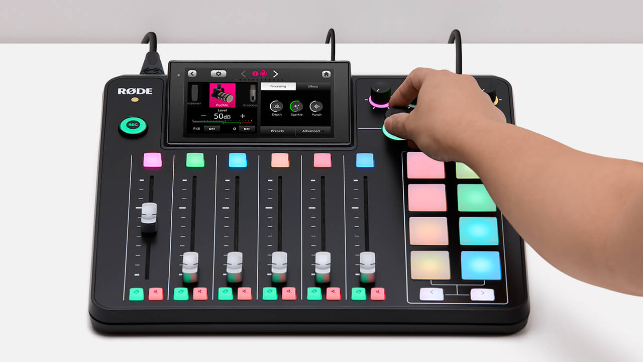 Hand adjusting RØDECaster Pro II knob with processing menu showing on display