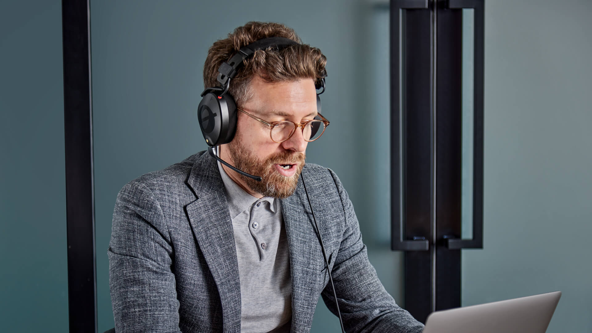 Man in front of laptop wearing NTH-100M