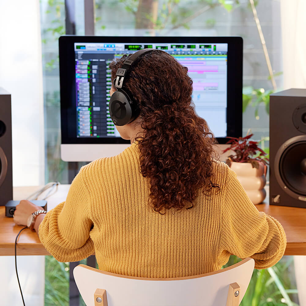 Girl wearing NTH-100 sitting in front of computer screen showing Pro Tools