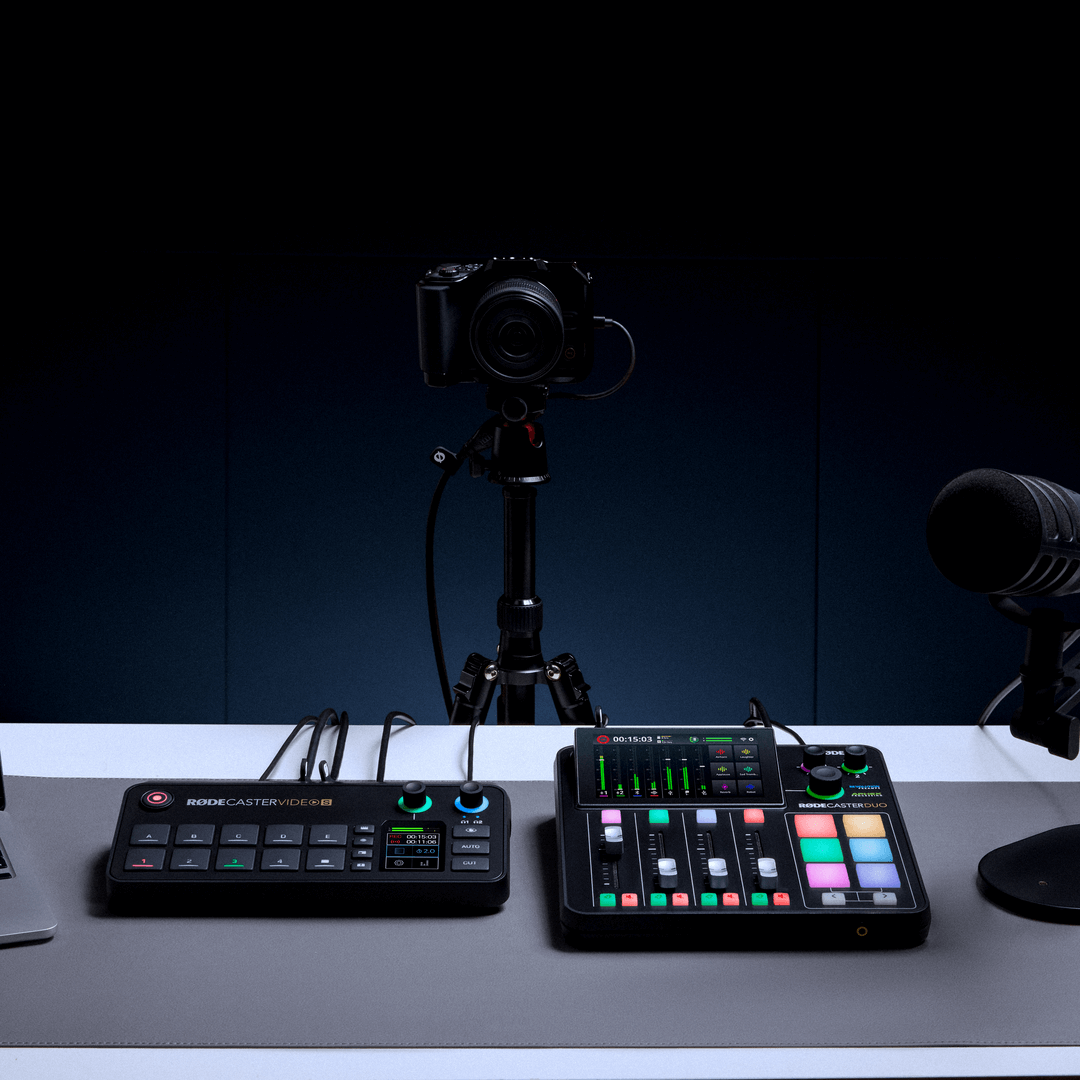 Person using PodMic USB and RØDECaster Video desk setup