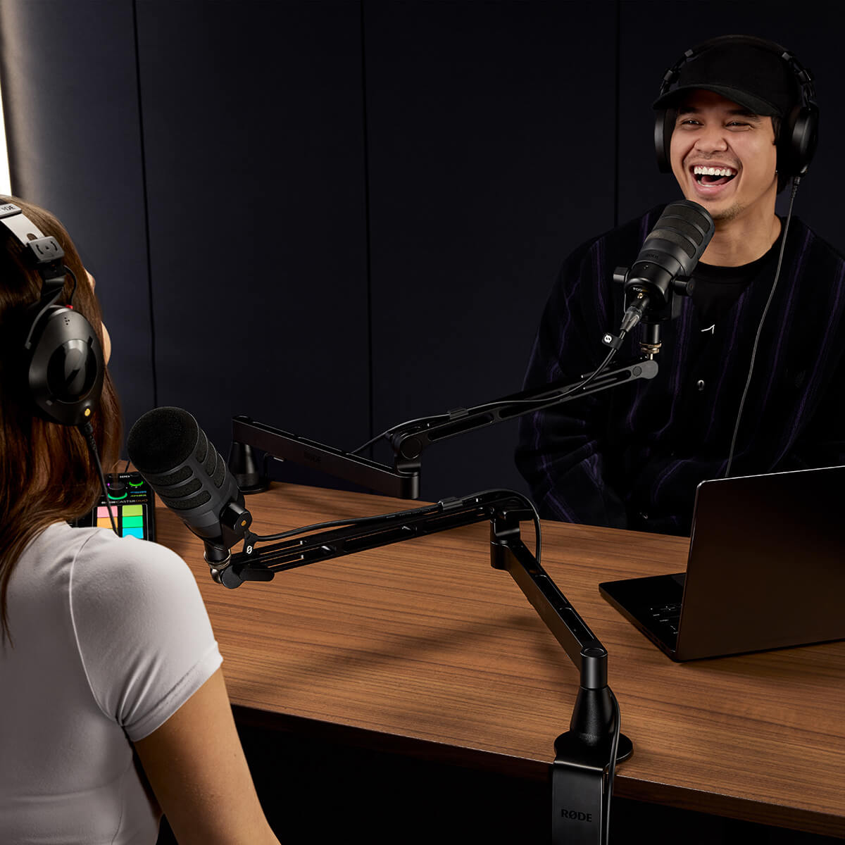 Two people recording a podcast at a desk.