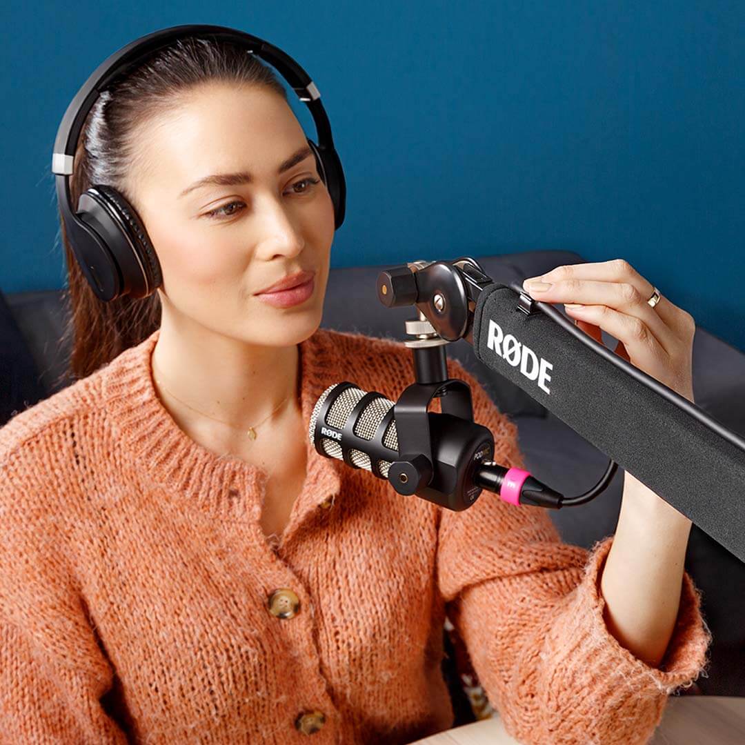 Woman wearing headphones adjusting cable on a PSA1+ with a PodMic mounted